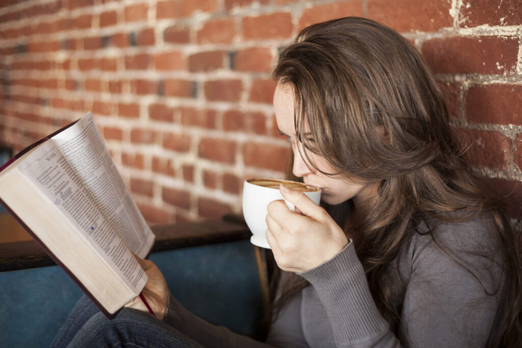 Woman drinking coffee and reading bible